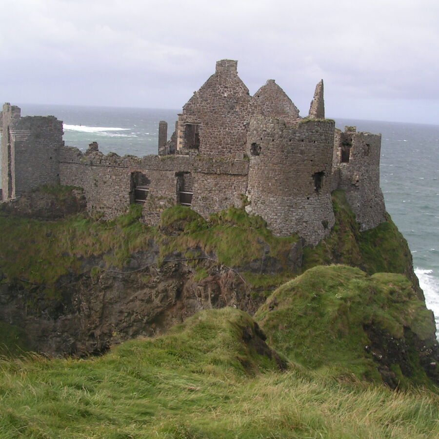 Castle ruins on a green cliff above the sea